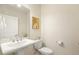 A well-lit powder room with a pedestal sink, modern faucet, and a convenient toilet with decor at 1304 Essex Skipper Way, Fuquay Varina, NC 27526