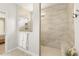 Tiled shower with glass surround features a shower head and bench at 1304 Essex Skipper Way, Fuquay Varina, NC 27526
