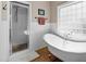 Bright bathroom with a clawfoot tub, glass enclosed shower, white subway tiles, and natural light from the window at 1329 Wynncrest Ct, Raleigh, NC 27603