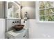 Charming bathroom showcasing unique copper vessel sink, updated fixtures, and natural light from the window at 1329 Wynncrest Ct, Raleigh, NC 27603