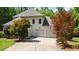 Back exterior view of home with three-car garage, mature landscaping, and ample driveway space at 1329 Wynncrest Ct, Raleigh, NC 27603
