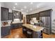 Beautiful kitchen featuring dark cabinetry, a granite island, stainless appliances, and wood floors at 1329 Wynncrest Ct, Raleigh, NC 27603