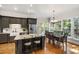 Open kitchen featuring an island, stainless appliances, and a dining area with natural light at 1329 Wynncrest Ct, Raleigh, NC 27603