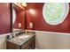 Stylish powder room with a round window and designer fixtures at 1329 Wynncrest Ct, Raleigh, NC 27603