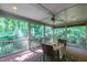 Screened porch with dining table offering serene views of the lush greenery and surrounding landscape at 1329 Wynncrest Ct, Raleigh, NC 27603