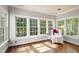 Bright sunroom with hardwood floors, a comfortable chair and views of the outside at 1329 Wynncrest Ct, Raleigh, NC 27603
