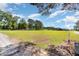 A wide view of the spacious front yard and its well-maintained lawn and distant outbuildings at 155 G Herring Rd, Princeton, NC 27569