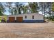 View of the property's blue and white garage with two brown roll-up doors at 155 G Herring Rd, Princeton, NC 27569