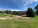 A grassy backyard with a fire pit, outbuilding, and a wooden deck at 165 Dawn Rd, Benson, NC 27504