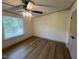 This bedroom features wood-look floors, a ceiling fan, and a bright window at 165 Dawn Rd, Benson, NC 27504
