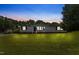 Inviting one-story home with freshly mowed lawn, vinyl siding, and warm exterior lighting at 165 Dawn Rd, Benson, NC 27504
