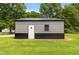 Metal detached garage with a white door, dark trim, and adjacent window at 165 Dawn Rd, Benson, NC 27504
