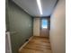 Hallway with an exit door, wood look flooring and olive accent walls at 165 Dawn Rd, Benson, NC 27504