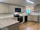 Modern kitchen featuring granite countertops, stainless steel appliances, and subway tile backsplash at 165 Dawn Rd, Benson, NC 27504