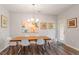 Bright dining room with modern lighting, a wooden table, and sleek white chairs at 174 Walking Path Pl, Hillsborough, NC 27278