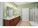 Bathroom featuring a double sink vanity, a shower, and a large mirror with lighting at 204 Dowington Ln, Cary, NC 27519