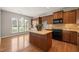 This kitchen showcases wood cabinets, hardwood floors, a center island, and modern appliances at 204 Dowington Ln, Cary, NC 27519