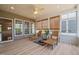 Relaxing sunroom offers natural light, wood floors, woven shades, ceiling fan, and comfortable lounge chairs at 204 Dowington Ln, Cary, NC 27519