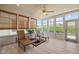 Bright sunroom features wood-look floors, woven shades, and large windows overlooking the lush outdoors at 204 Dowington Ln, Cary, NC 27519