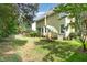 An inviting backyard featuring a lush lawn, mature trees, and outdoor seating beneath a shade umbrella at 209 Woodstar Dr, Cary, NC 27513