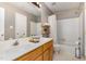 Well-lit bathroom with double vanity, shower-tub combo, and neutral decor at 209 Woodstar Dr, Cary, NC 27513