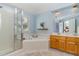 Bright bathroom featuring a shower, soaking tub, double sink vanity, and blue accent walls at 209 Woodstar Dr, Cary, NC 27513