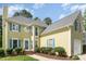 Charming home featuring a welcoming entrance, beautiful landscaping, and light yellow siding with blue shutters at 209 Woodstar Dr, Cary, NC 27513