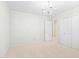 This is a spacious bedroom with white walls and carpet, featuring a closet and decorative chandelier at 2107 Somers Ave, Burlington, NC 27215