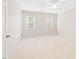 Cozy bedroom featuring neutral carpet, white walls, and two windows offering plenty of natural light at 2107 Somers Ave, Burlington, NC 27215