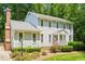 Classic two-story home boasts a brick chimney, landscaped garden beds, and a welcoming front porch at 2107 Somers Ave, Burlington, NC 27215