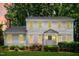 Charming two-story home with classic architecture, covered front porch and colorful flowering plants at 2107 Somers Ave, Burlington, NC 27215