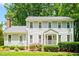 Charming two-story house features flowering bushes, healthy shrubs, and a cozy covered entrance at 2107 Somers Ave, Burlington, NC 27215