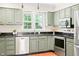 Close-up of a kitchen with stainless steel appliances, ample counter space, and window for natural light at 2107 Somers Ave, Burlington, NC 27215