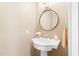 Simple powder room with pedestal sink, round mirror, and neutral paint tones at 2107 Somers Ave, Burlington, NC 27215