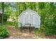 Backyard shed with double doors, surrounded by trees, offering practical storage and a fenced yard at 2107 Somers Ave, Burlington, NC 27215