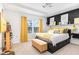 Stylish bedroom with a tray ceiling, black accent wall, and sunny yellow decor accents at 217 Jones Hill Rd, Holly Springs, NC 27540