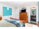 Bedroom featuring a wood dresser with an adjacent bathroom and a turquoise accent wall at 217 Jones Hill Rd, Holly Springs, NC 27540