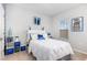 Cozy bedroom with a white bed, blue accents, and a bright window with views of the exterior at 217 Jones Hill Rd, Holly Springs, NC 27540