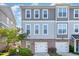 Stylish townhome featuring a brick facade, two-car garage, and neutral-toned siding for a modern look at 217 Jones Hill Rd, Holly Springs, NC 27540