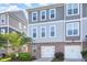 Stylish townhome featuring a brick facade, two-car garage, and neutral-toned siding for a modern look at 217 Jones Hill Rd, Holly Springs, NC 27540