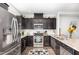 Well-equipped kitchen featuring stainless steel appliances, dark cabinets, and granite countertops at 217 Jones Hill Rd, Holly Springs, NC 27540