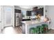 Modern kitchen features granite countertops, dark cabinetry, and stainless steel appliances at 217 Jones Hill Rd, Holly Springs, NC 27540