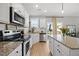 Open kitchen with stainless steel appliances and a granite island at 225 Alcock Ln, Youngsville, NC 27596