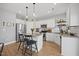 Well-lit kitchen with white cabinets, granite countertops, and a breakfast bar at 225 Alcock Ln, Youngsville, NC 27596
