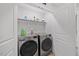 Clean and organized laundry room with modern, front-loading washer and dryer units at 225 Alcock Ln, Youngsville, NC 27596