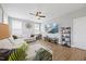 Bright living area with an expansive white couch, large television, ceiling fan, and hardwood flooring at 225 Alcock Ln, Youngsville, NC 27596