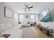 Bright living area with an expansive white couch, large television, ceiling fan, and hardwood flooring at 225 Alcock Ln, Youngsville, NC 27596