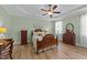 This primary bedroom has a tray ceiling, wood floors, ceiling fan, and neutral paint at 232 Shady Hollow Ln, Garner, NC 27529