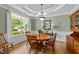 Bright dining room featuring a round wooden table, matching chairs, large window, and traditional wainscoting details at 232 Shady Hollow Ln, Garner, NC 27529