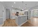Modern kitchen with white cabinets, stainless steel appliances, breakfast bar, and hardwood floors under recessed lights at 232 Shady Hollow Ln, Garner, NC 27529